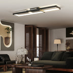 Lámpara de techo LED rectangular encendida en un salón moderno con sofá oscuro y mesa de centro