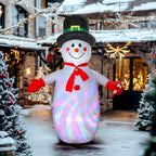 Muñeco de nieve hinchable iluminado en una calle nevada con luces navideñas