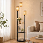 Lámpara de pie boho con tres pantallas de cuerda de papel y estantes decorados junto a un sillón