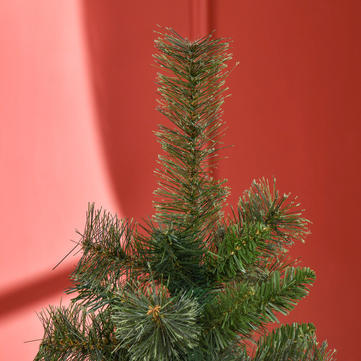 Parte superior del árbol de Navidad sobre una pared roja