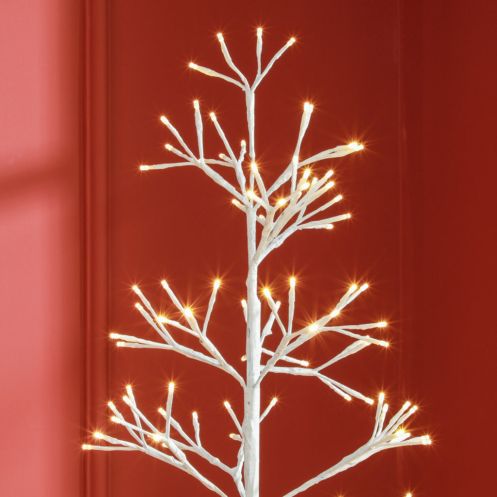 Árbol de Navidad iluminado junto a una ventana