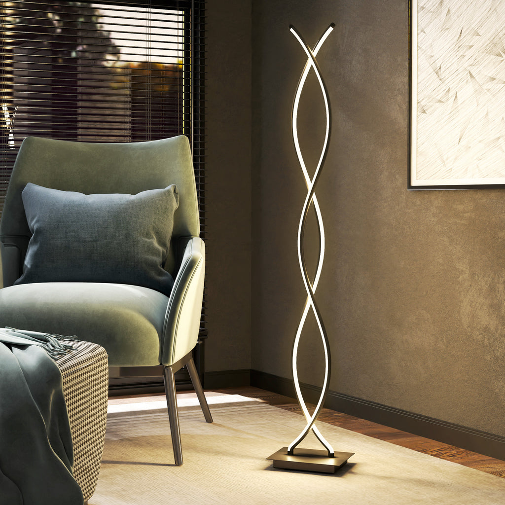 Lámpara de pie LED de doble espiral encendida junto a un sillón verde en un salón