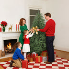 Familia decorando un abeto de Navidad junto a una chimenea con regalos