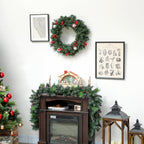 Corona de Navidad con luces cálidas en una pared blanca junto a un cuadro y una cómoda