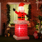 Papá Noel hinchable en una chimenea iluminada junto a una ventana de una casa de ladrillo