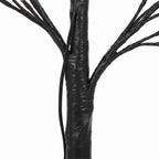 Detalle del tronco negro y las ramas flexibles del árbol luminoso
