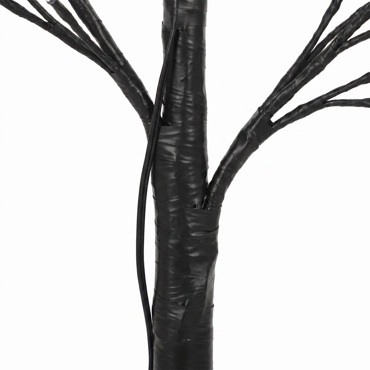Detalle del tronco negro y las ramas flexibles del árbol luminoso
