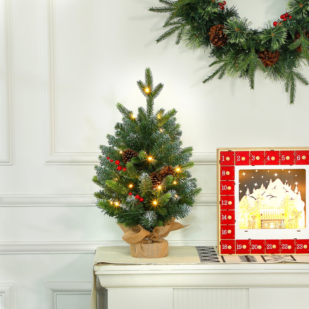 Árbol de Navidad de mesa junto a una corona navideña