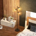 Lámpara de pie en forma de árbol encendida en un dormitorio junto a la cama
