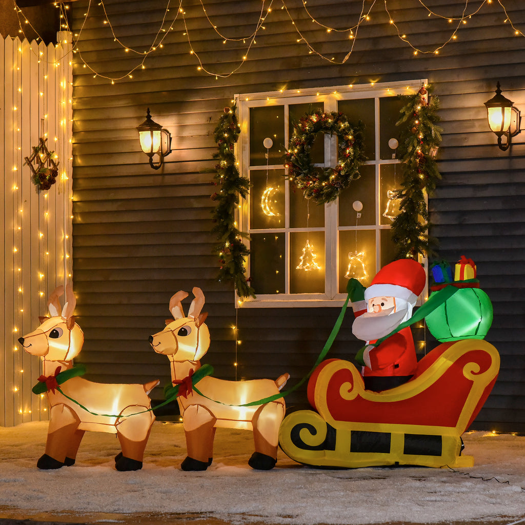 Papá Noel con trineo y renos hinchables iluminados junto a una casa con corona navideña