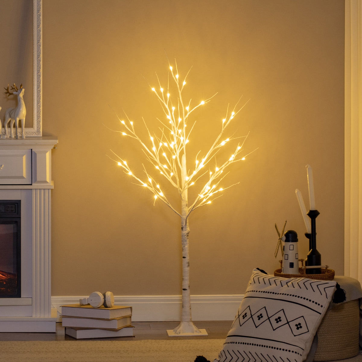 Árbol luminoso de abedul LED de 120 cm encendido en un salón junto a una chimenea, con luz cálida