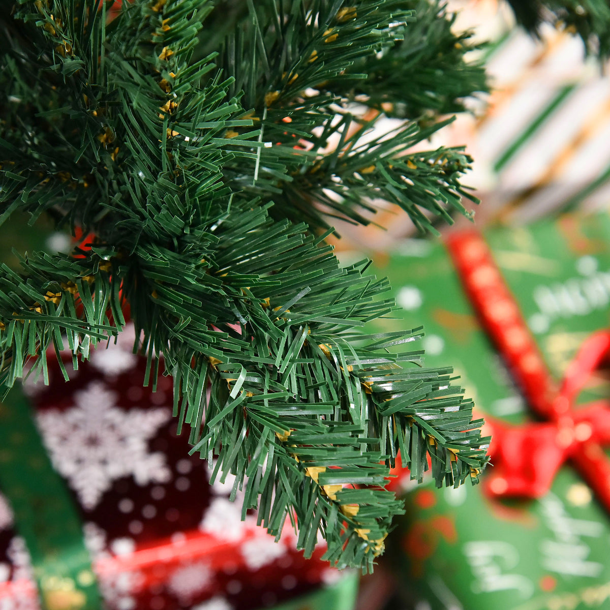 Detalle de las agujas de pino del abeto de Navidad junto a un regalo