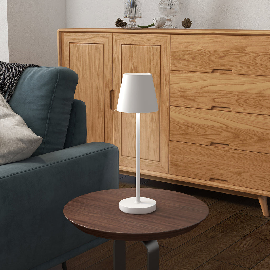 Lámpara de mesa blanca recargable en una mesita de noche