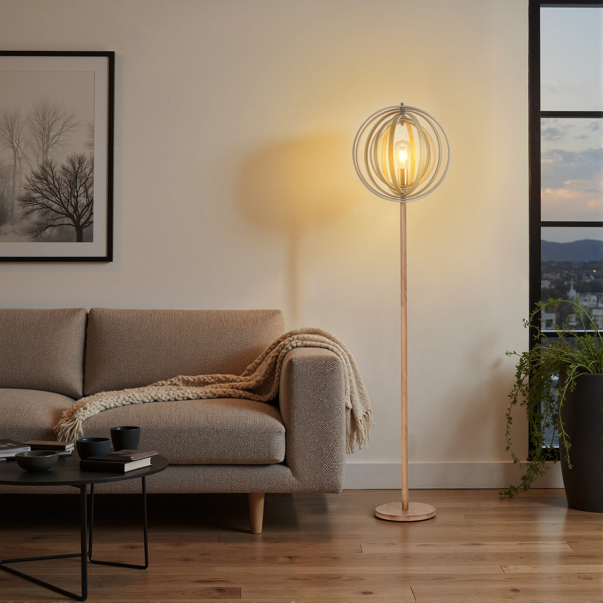 Lámpara de pie de aros de madera encendida junto a un sofá gris y una mesa de centro
