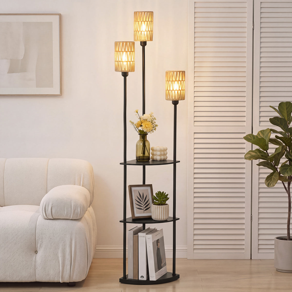 Lámpara de pie boho con tres pantallas de cuerda de papel encendidas junto a un sofá blanco y estantes decorados