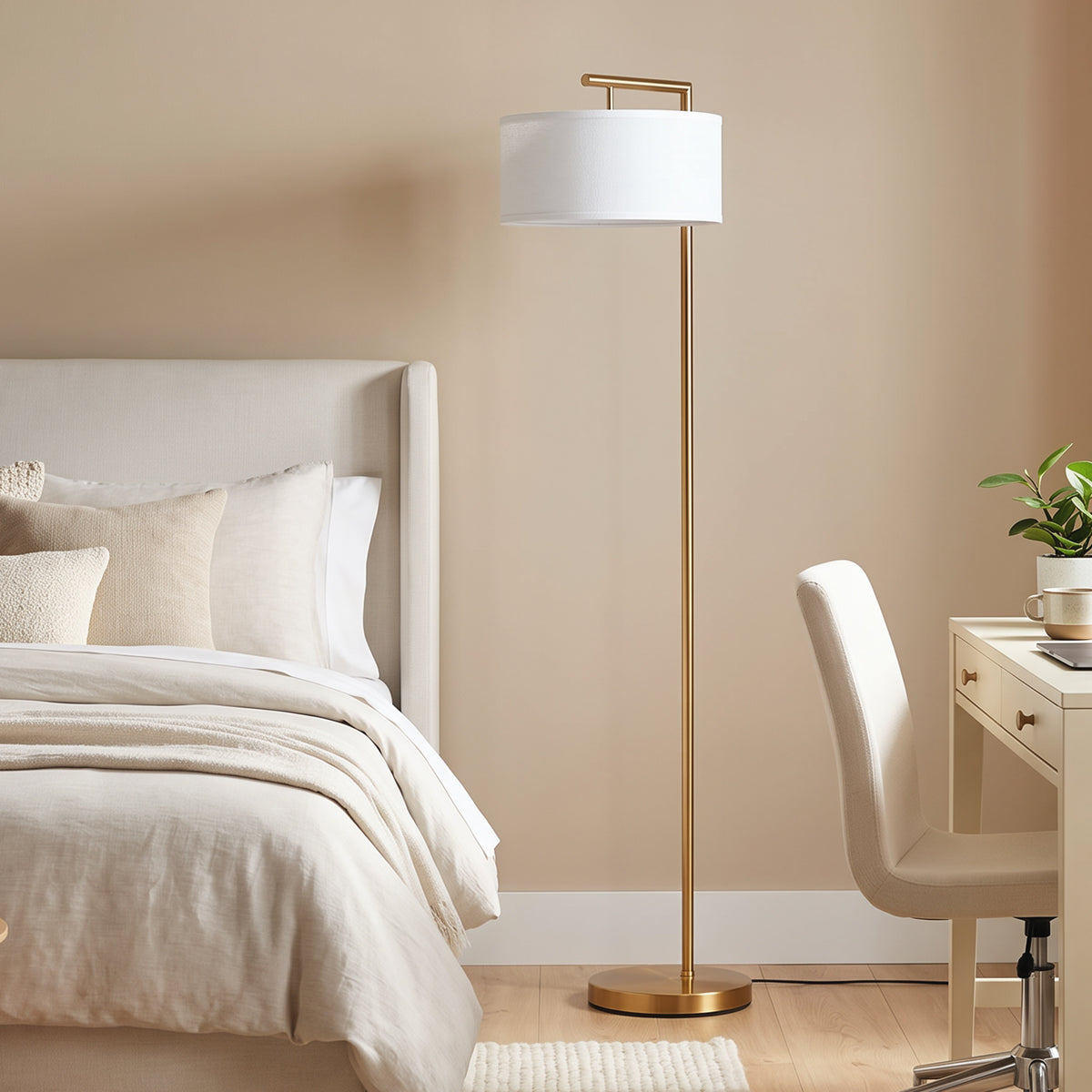 Lámpara de pie dorada junto a una cama con ropa de cama blanca y una silla de escritorio