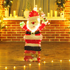 Papá Noel luminoso encendido junto a una pared de ladrillo y velas
