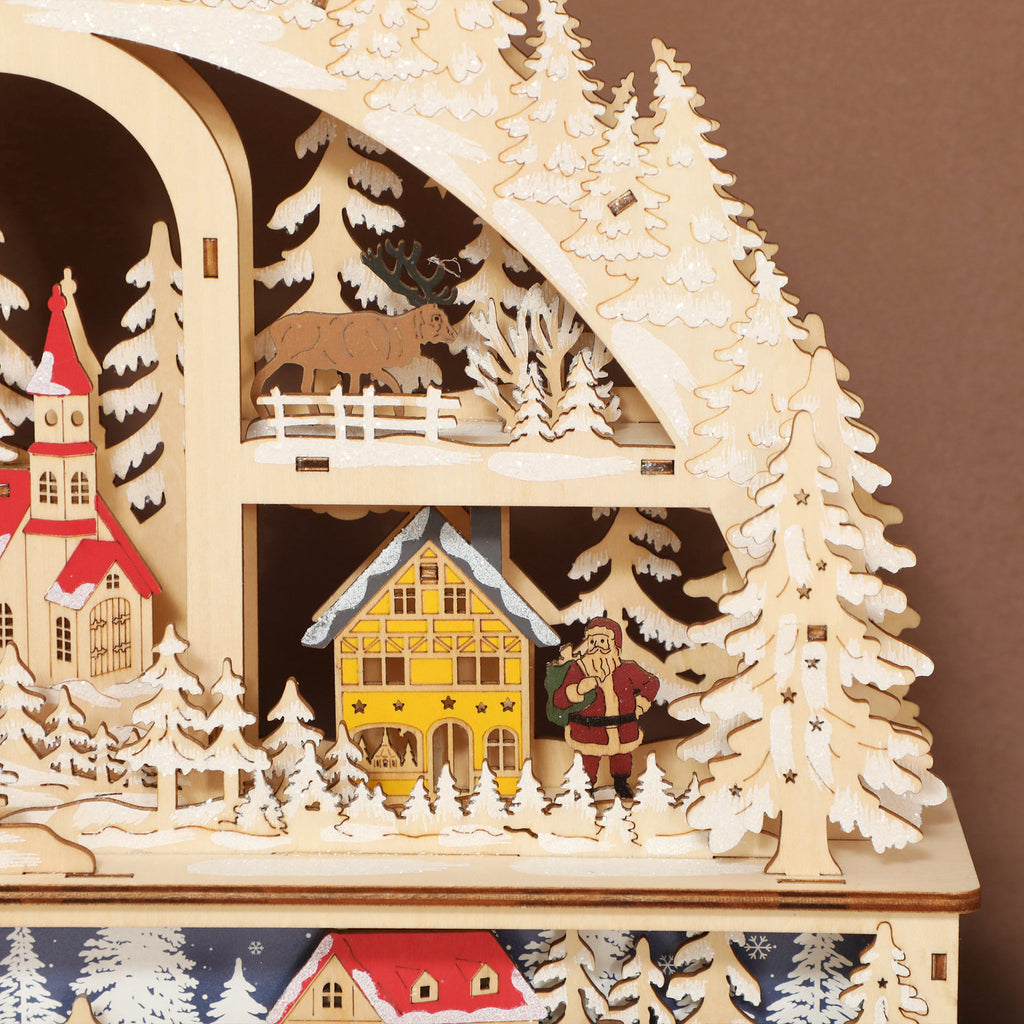 Detalle de las casitas, los abetos nevados y el reno del pueblo navideño de madera
