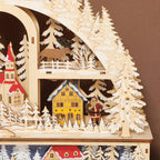 Detalle de las casitas, los abetos nevados y el reno del pueblo navideño de madera