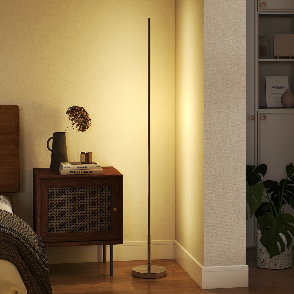Lámpara de pie LED encendida junto a una mesita de noche de ratán en un dormitorio