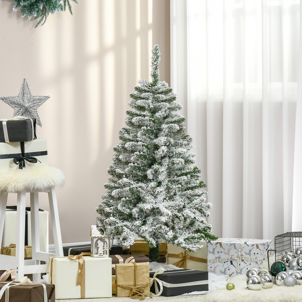 Árbol nevado de 120 cm junto a una ventana con regalos y adornos