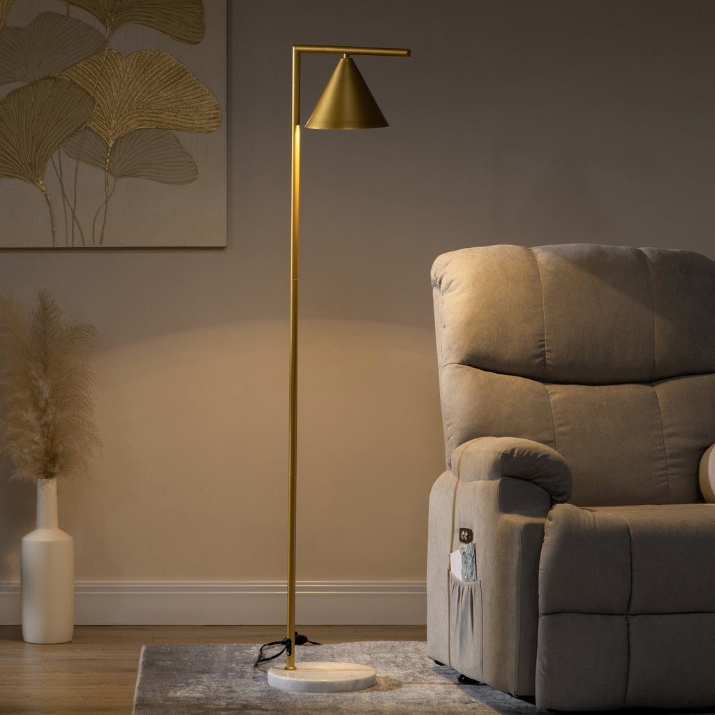 Lámpara de pie dorada encendida junto a un sillón y un jarrón en un salón