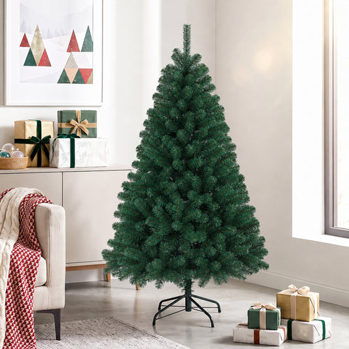 Abeto de Navidad artificial junto a un sofá con regalos y decoración navideña