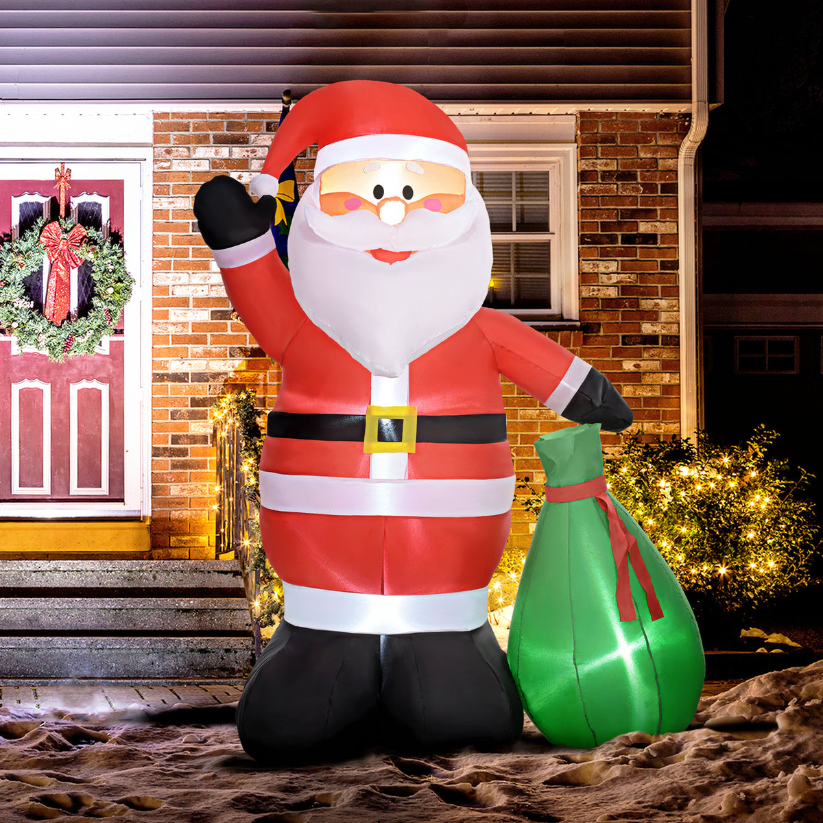 Papá Noel hinchable de 180 cm iluminado junto a una puerta con corona navideña por la noche