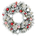Corona de Navidad nevada de 60 cm con bolas rojas y blancas, bastones de caramelo y bayas, vista frontal sobre fondo blanco