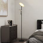 Lámpara de pie LED negra encendida junto a una cómoda y una cama en un dormitorio