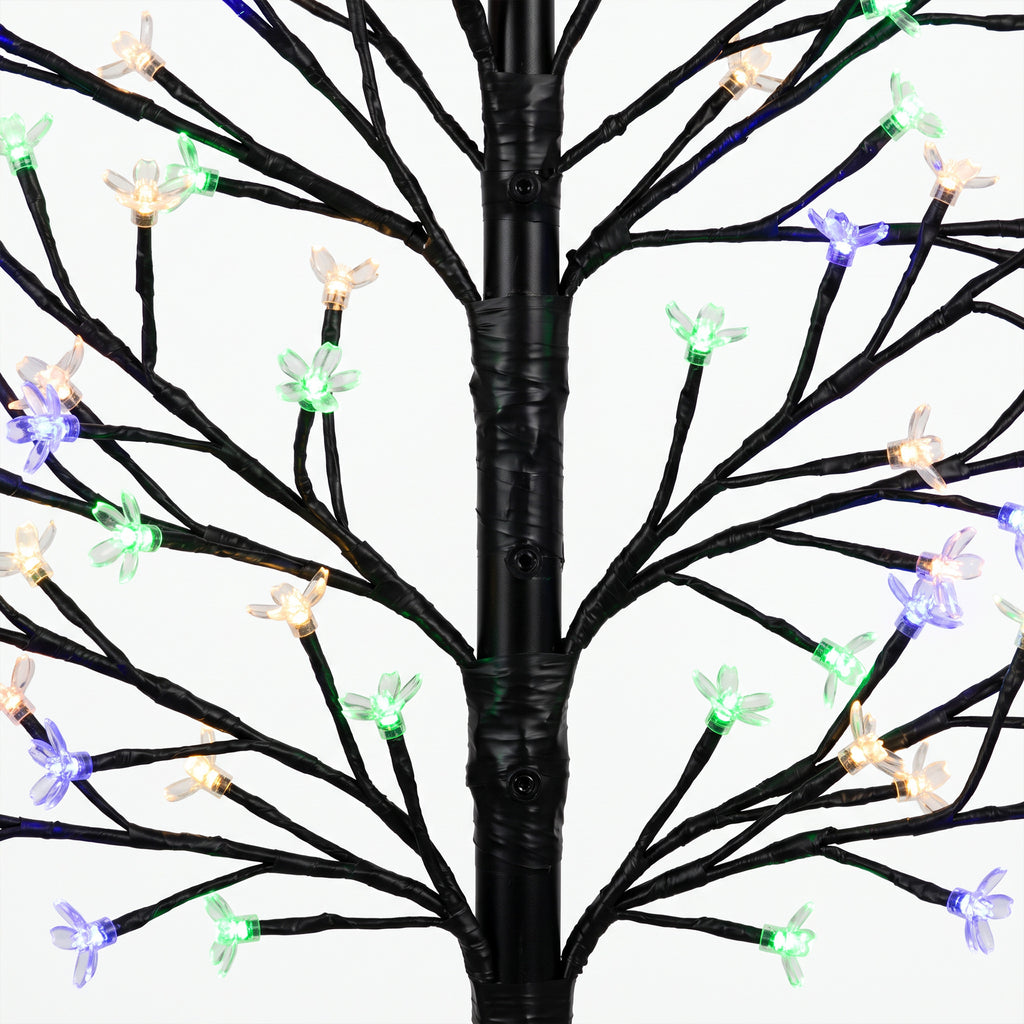 Detalle de las ramas del árbol luminoso con flores en luz multicolor