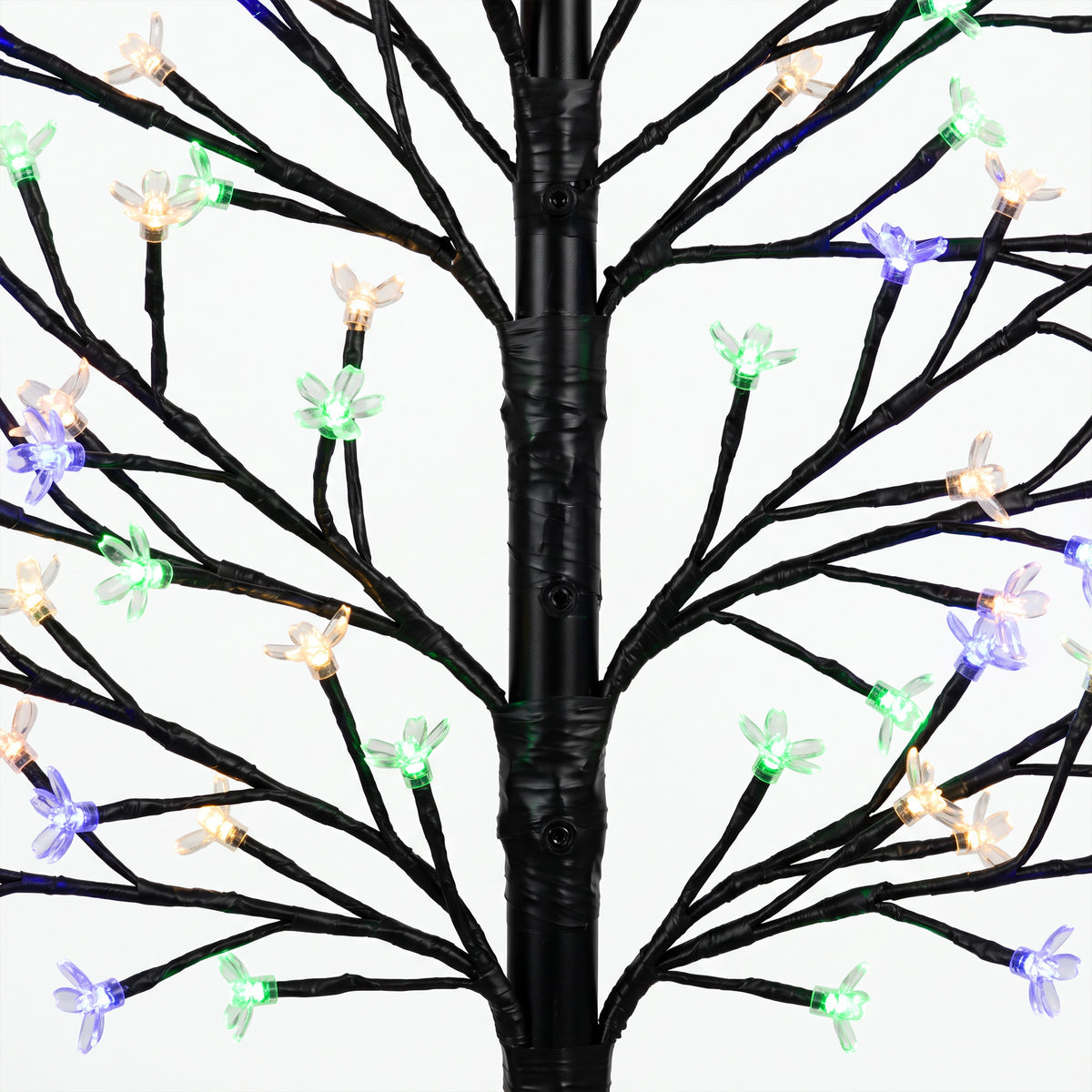 Detalle de las ramas del árbol luminoso con flores en luz multicolor