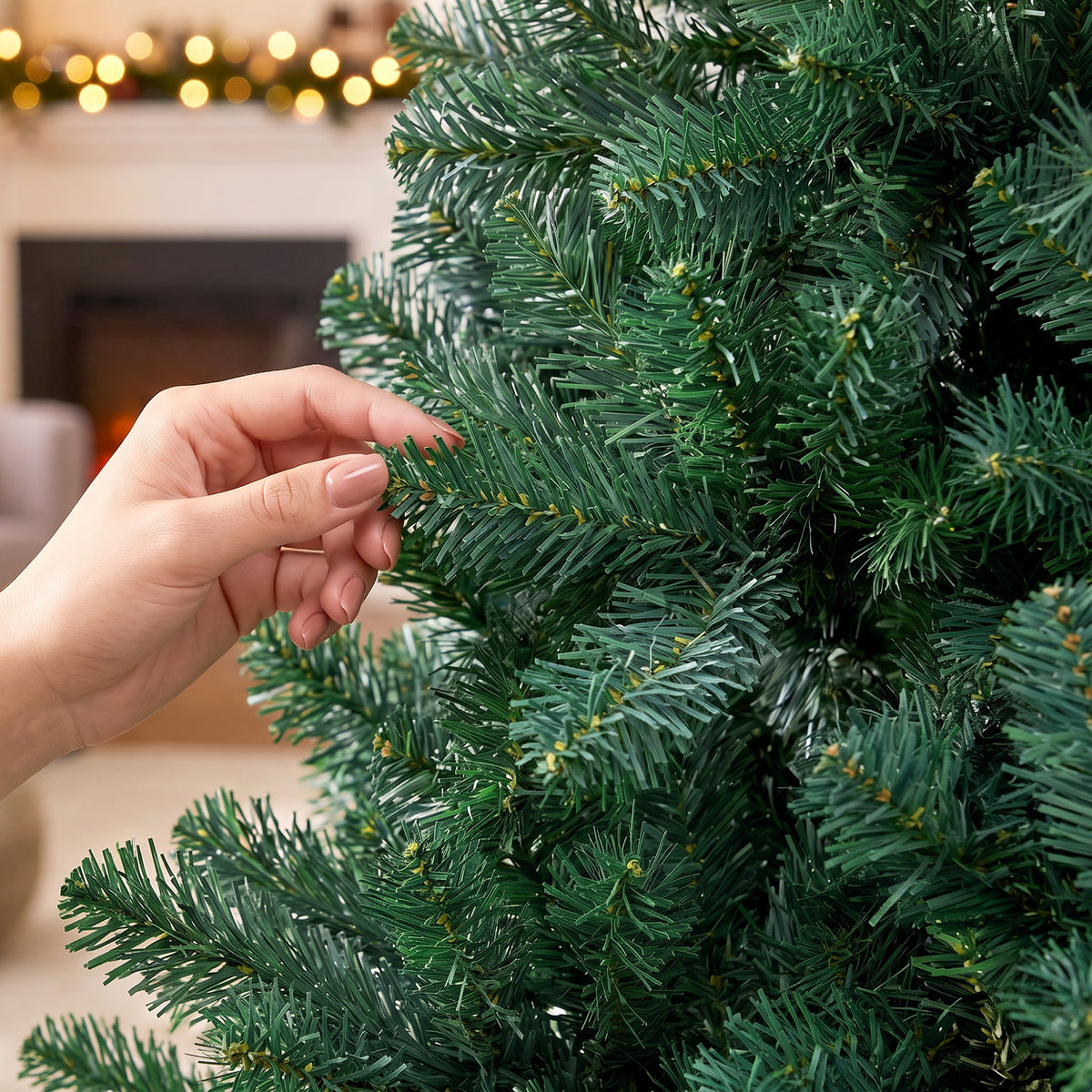 Detalle de las ramas verdes del abeto de Navidad sujetadas con la mano
