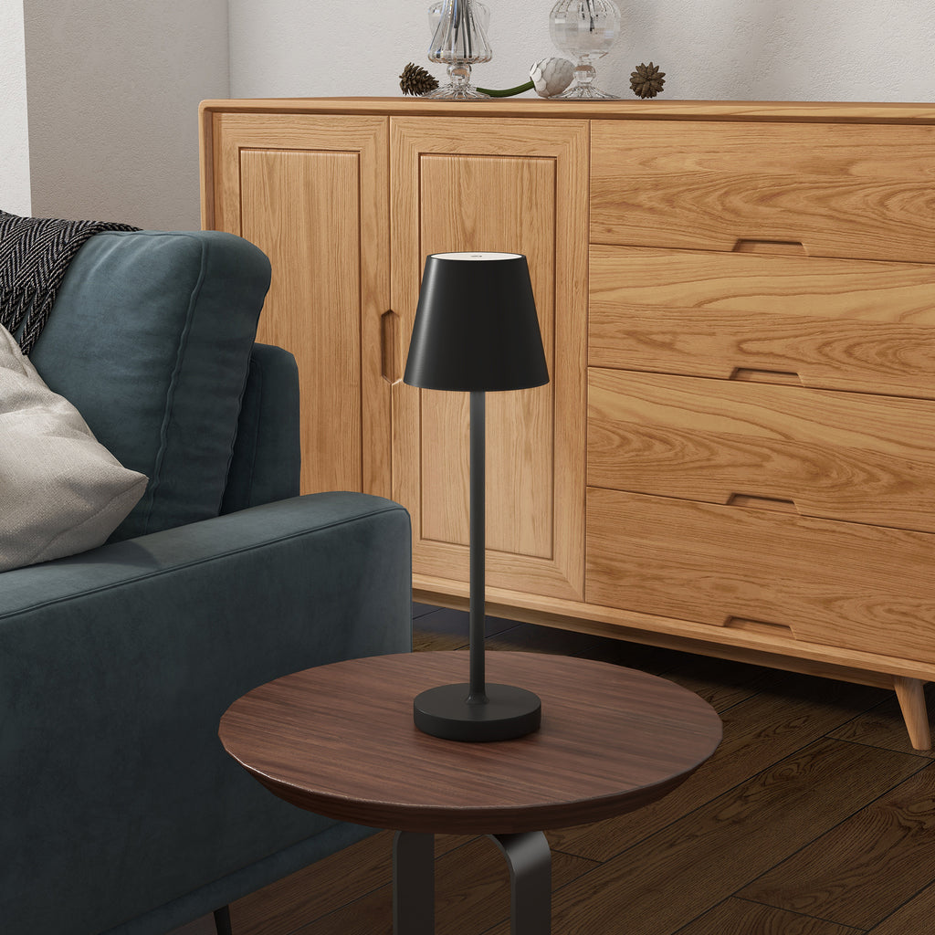 Lámpara de mesa negra recargable en una mesita de noche