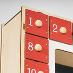 Detalle de los cajones numerados rojos con tirador de madera del calendario de Adviento