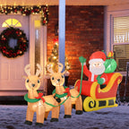 Papá Noel con trineo y renos hinchables iluminados junto a la puerta de una casa decorada