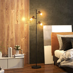 Lámpara de pie en forma de árbol encendida en un dormitorio con pared de madera