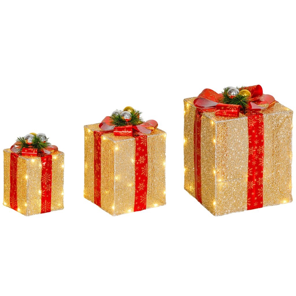 Tres cajas de regalo luminosas de distintos tamaños con lazo rojo sobre fondo blanco
