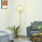 Lámpara de pie de aros de madera junto a un sillón gris y una planta en un salón