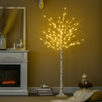 Árbol de abedul con luces LED junto a una chimenea y adornos navideños