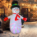Muñeco de nieve hinchable iluminado junto a la puerta de una casa decorada
